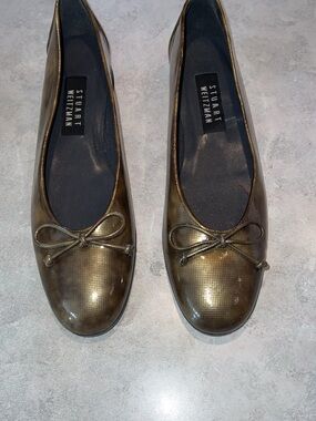 Stuart Weitzman ballerina flats featuring a textured, metallic green/gold finish
